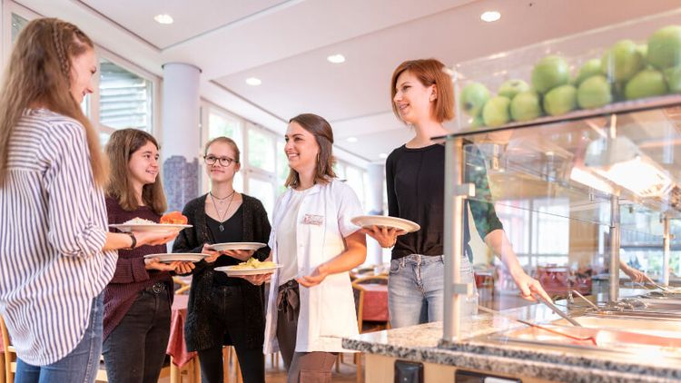 Junge Patientinnen suchen sich Essen aus in der Cafeteria