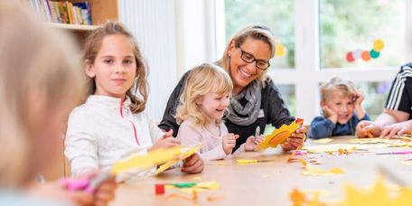 Kinderbetreuung in der Klinik Fachkraft bastelt mit kleinen Kindern