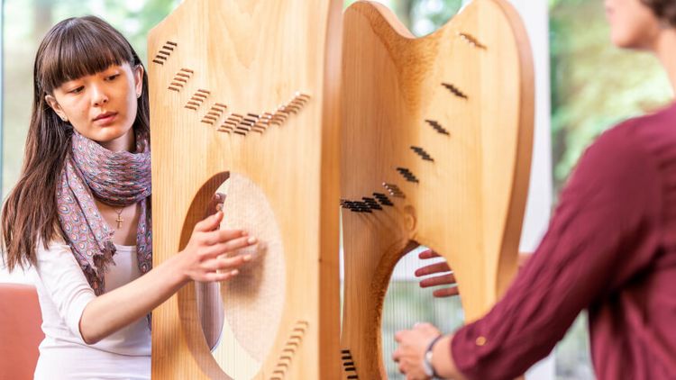 Patientin spielt Harfe in der Musiktherapie