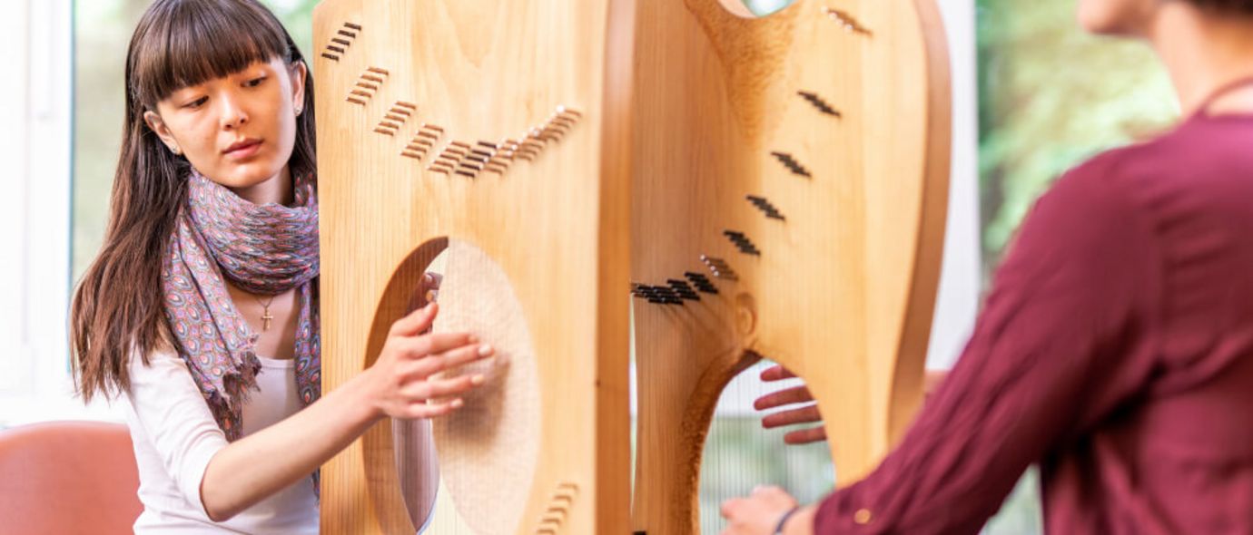 Patientin spielt Harfe in der Musiktherapie