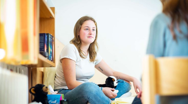 Junge Patientin spricht in ihrem Zimmer mit der Therapeutin