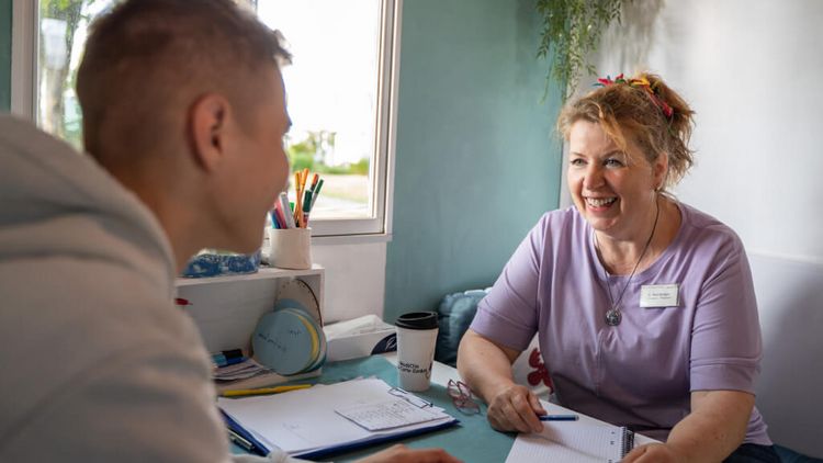Therapeutin spricht mit männlichem jugen Patienten