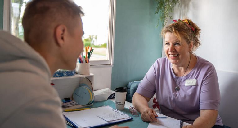 Therapeutin spricht mit männlichem jugen Patienten