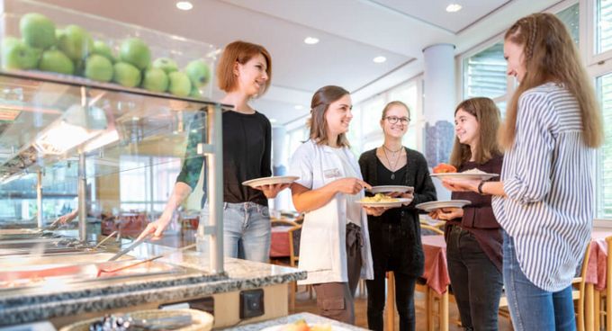 Gruppe Frauen in eine Cafeteria mit Essen in der Hand