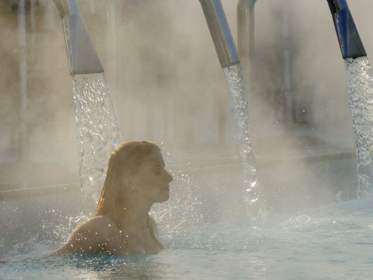 Junge Frau entspannt sich im Außenbecken eines Thermalbades
