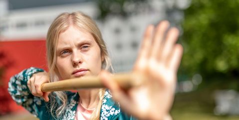 Patientinnen macht Qi Gong-Übung mit einem Stock