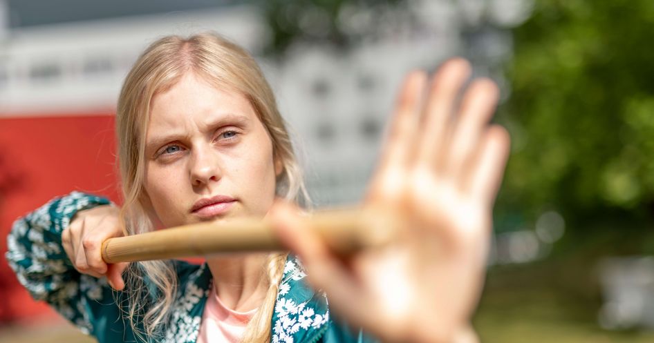 Patientinnen macht Qi Gong-Übung mit einem Stock