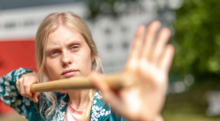 Patientinnen macht Qi Gong-Übung mit einem Stock