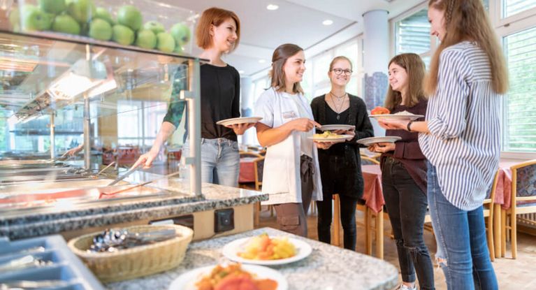 Junge Patientinnen suchen sich Essen aus in der Cafeteria