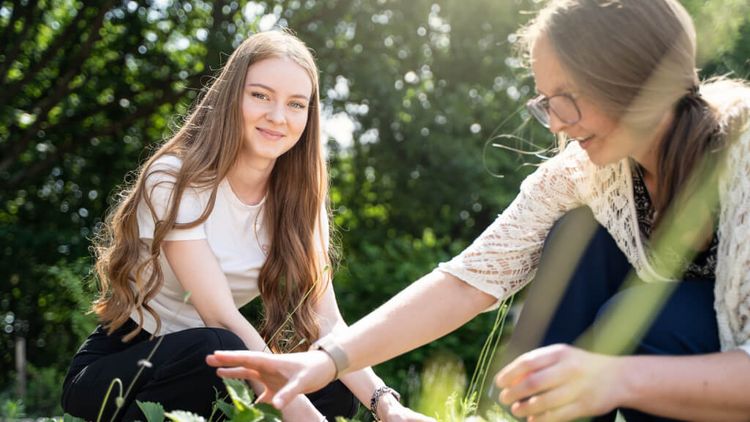 Junges Mädchen arbeitet mit Therapeutin im Garten