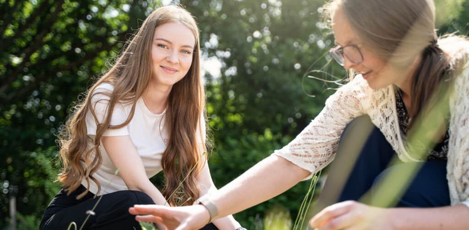 Junges Mädchen arbeitet mit Therapeutin im Garten
