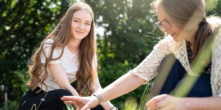Junges Mädchen arbeitet mit Therapeutin im Garten